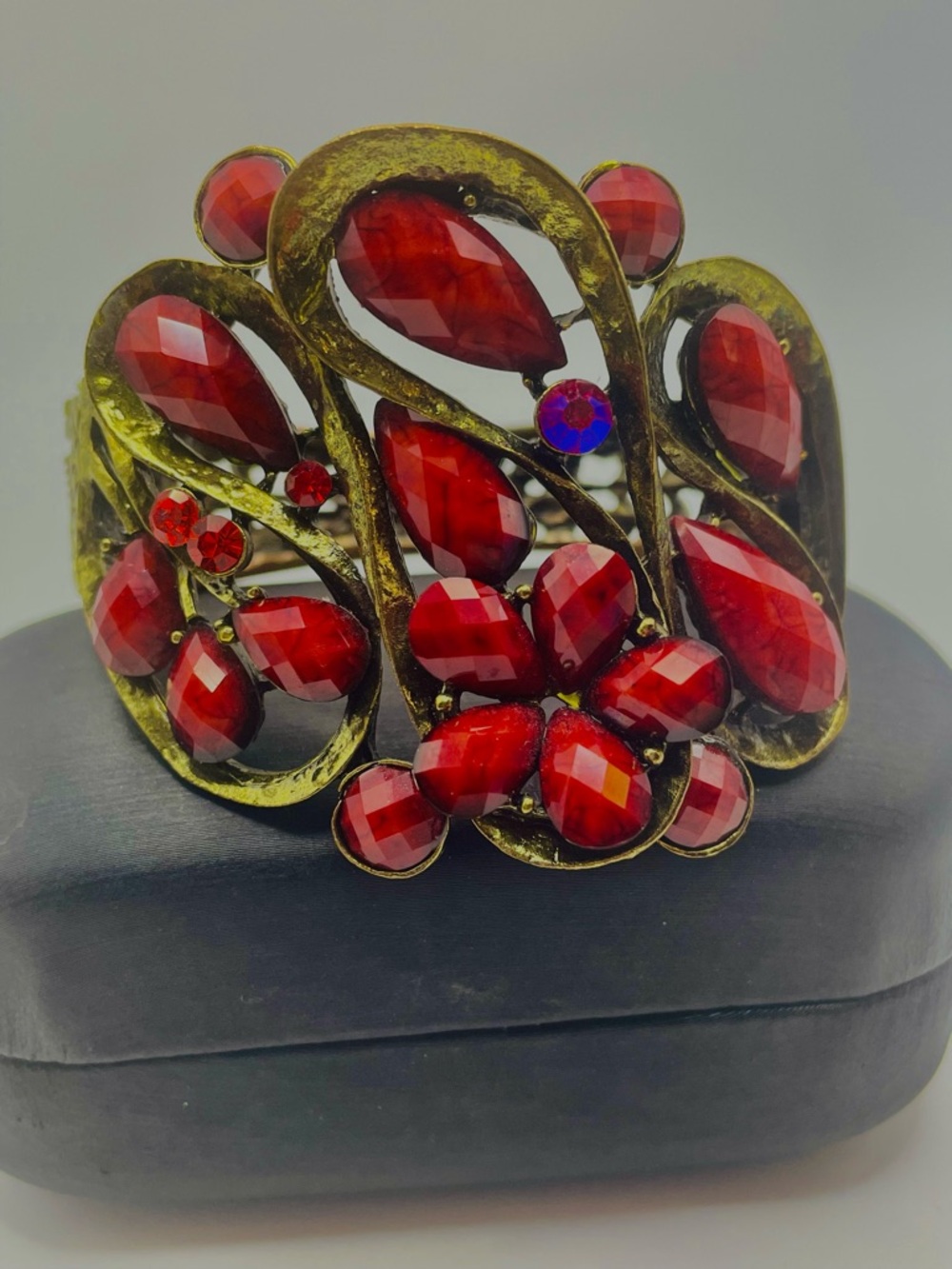 Red Rhinestone Ornate Floral Hinged Statement Clamper Bracelet. Gold tone. 7 in.